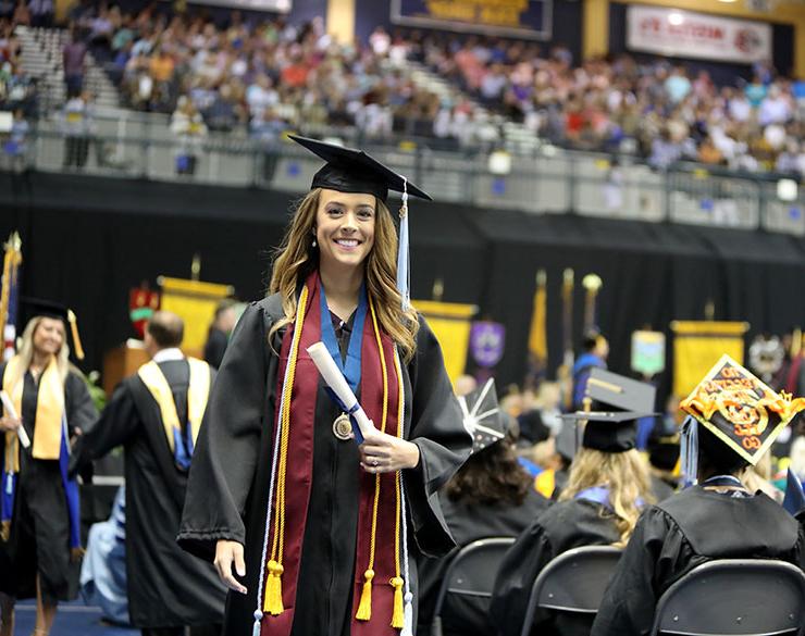 A woman smiles at commencement